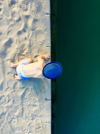 Directly above shot of shirtless boy by lake