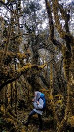 Full length of woman standing amidst trees