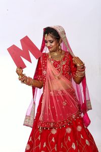 Woman with red umbrella standing against the wall