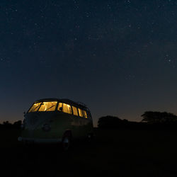 Vintage car on field against sky at night