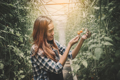 Young woman holding flowers in park