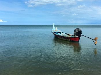 Fishing boat in sea against sky