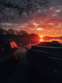 Boats on lake against during sunset