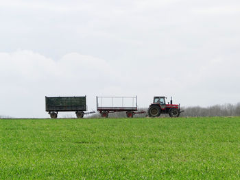 Tractor on agricultural field against sky