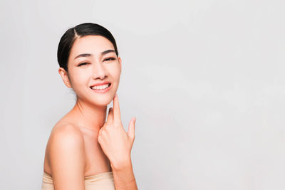 Woman looking away against white background