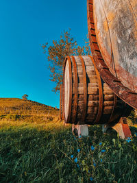 Rusty metallic structure on field against clear blue sky