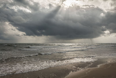 Scenic view of sea against storm clouds