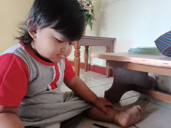 Boy looking away while sitting at home