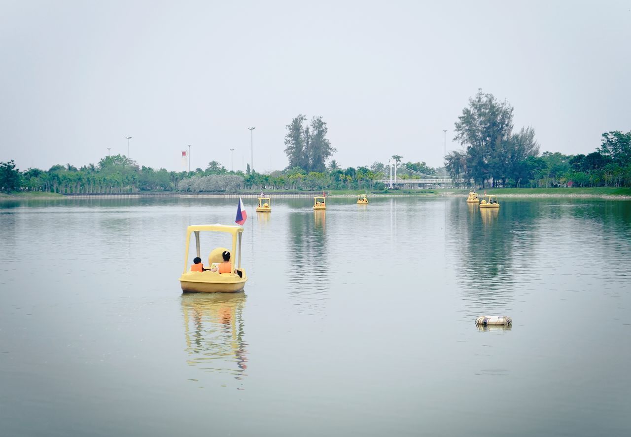 BOATS IN LAKE AGAINST CLEAR SKY