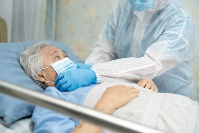 Midsection of doctor examining senior patient in hospital
