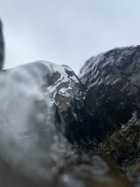 Close-up of rock formation against sky during winter