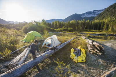 Young boy exploring near campsite in mountains, whistler, b.c.