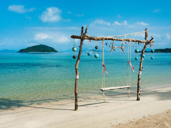 Scenic white sand beach island with wooden swing and turquoise sea. koh mak island, trat, thailand.