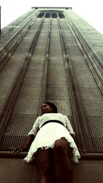 Low angle view of woman standing against wall