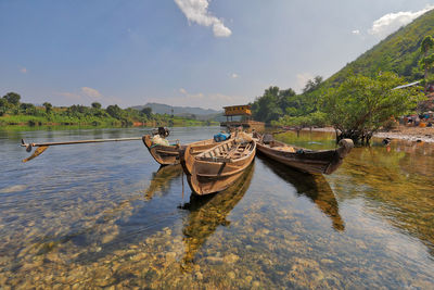 Boat moored in lake against sky