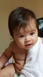 Close-up portrait of cute shirtless baby girl at home