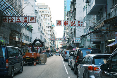 Traffic on road amidst buildings in city