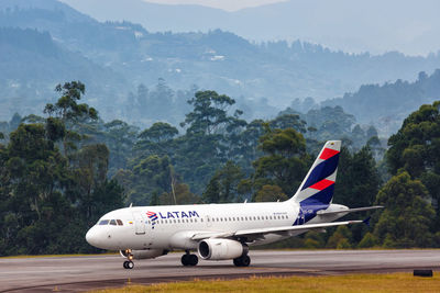 Airplane on runway against mountains