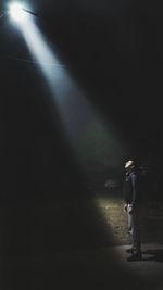 Side view of man walking on street at night