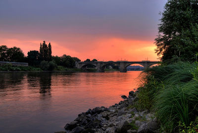 Bridge over river against sky during sunset