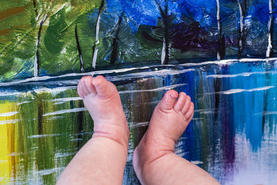 Cropped image of person hand on glass against plants