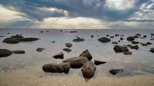 Rocks in sea against sky