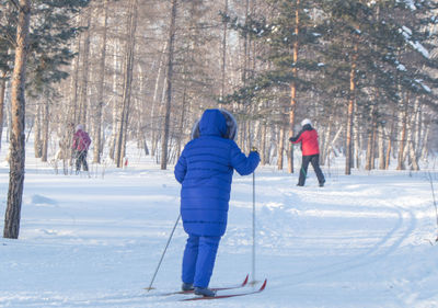 Rear view of people on snow covered land