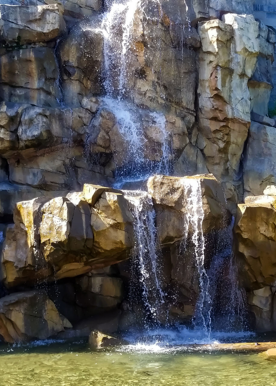 WATER FLOWING THROUGH ROCKS IN WATERFALL