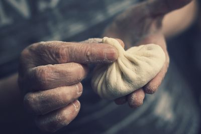 Midsection of person making dumpling