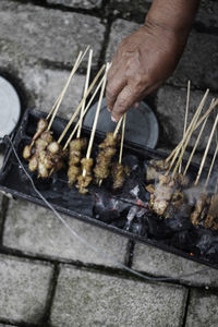 Close-up of man preparing food on barbecue grill