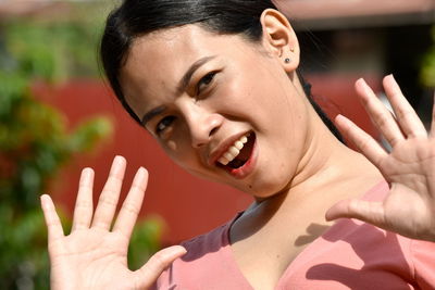 Close-up portrait of smiling woman gesturing outdoors