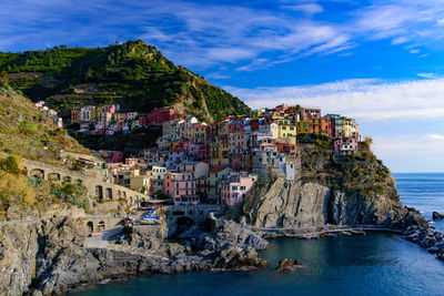 Scenic view of sea by buildings against sky