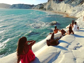 Man and women relaxing on rocks at scala dei turchi