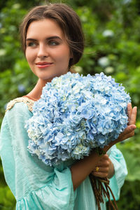 Portrait of young woman holding bouquet