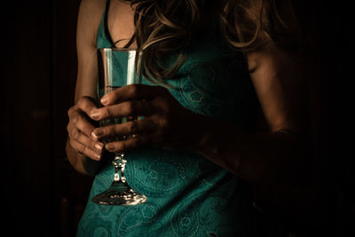 Midsection of woman holding wineglass