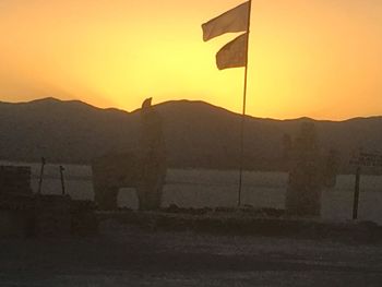 Scenic view of silhouette mountains against orange sky