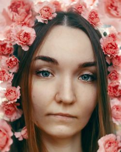 Close-up portrait of woman with pink flowers