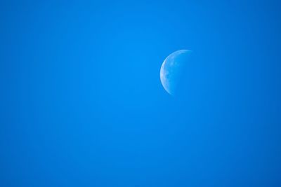 Low angle view of moon against blue sky