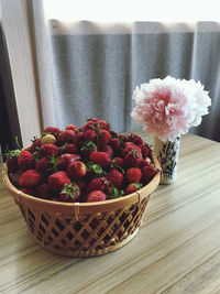Close-up of red flowers in basket on table