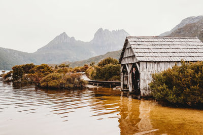 Woman standing inside the old boat shed next to lake on a wintery day