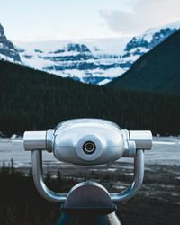 Close-up of coin-operated binoculars against sky