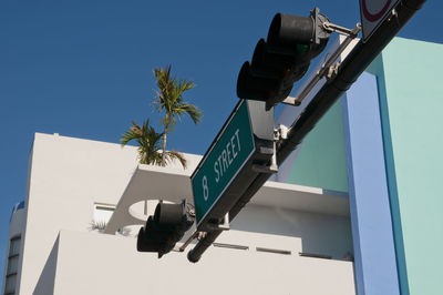 Street sign  8 street in miami beach with a traffic light, in the background city buildings.