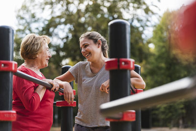 Grandmother and granddaughter training on bars in a park