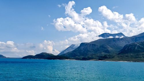 Scenic view of sea and mountains against sky