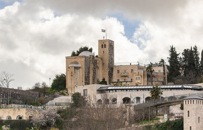 Buildings in city against cloudy sky