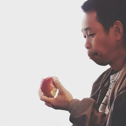 Close-up of man eating food against white background