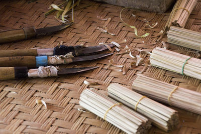 High angle view of knives on bamboo mat