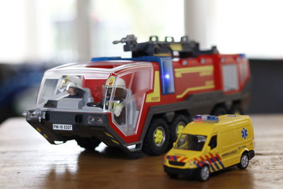 Close-up of toy fire engine and ambulance on table