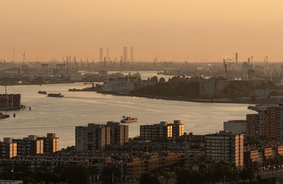 High angle view of buildings and river against sky during sunset