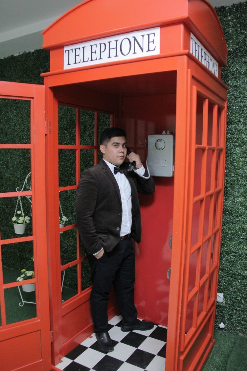 FULL LENGTH OF MAN STANDING BY RED PHONE